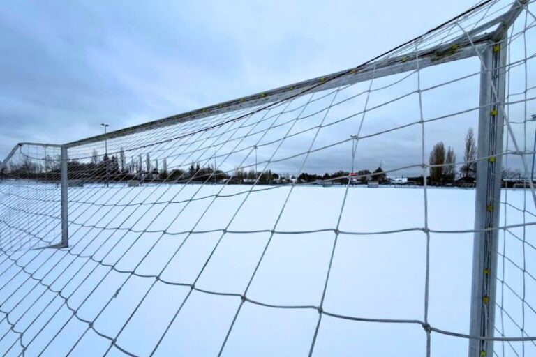 Kunstgræsbane dækket af sne