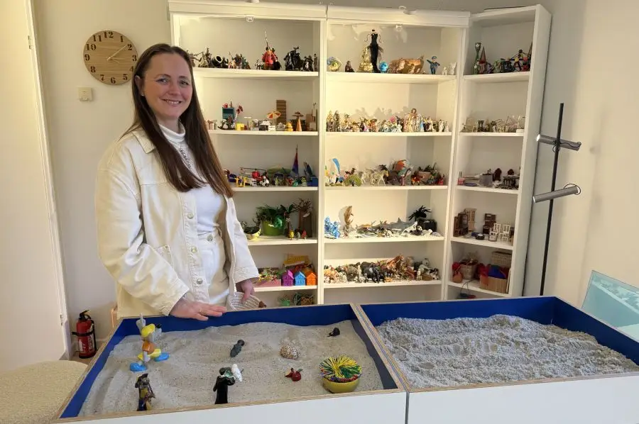 Kvinde foran reoler med figurer