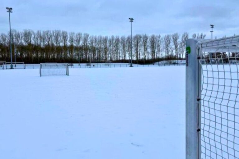 Kunstgræsbane dækket af sne