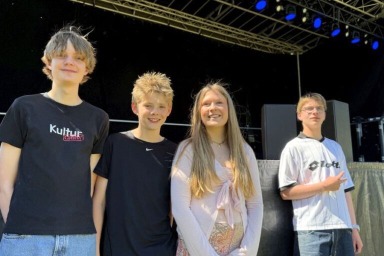Fire unge foran en scene
